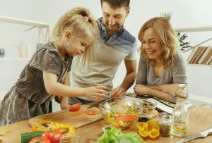 Familia cocinando recetas saludables para niños para comer sano después de Navidad.